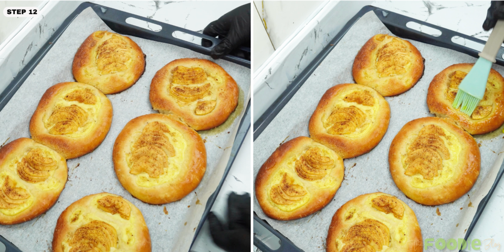 A baking tray of baked apple-and-cream brioche as a brush spreads apricot glaze for shine.