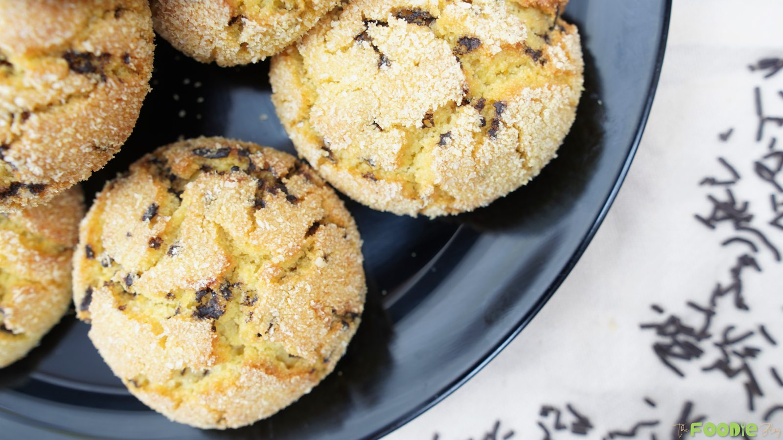Golden semolina cookies on a dark plate with chocolate sprinkles nearby