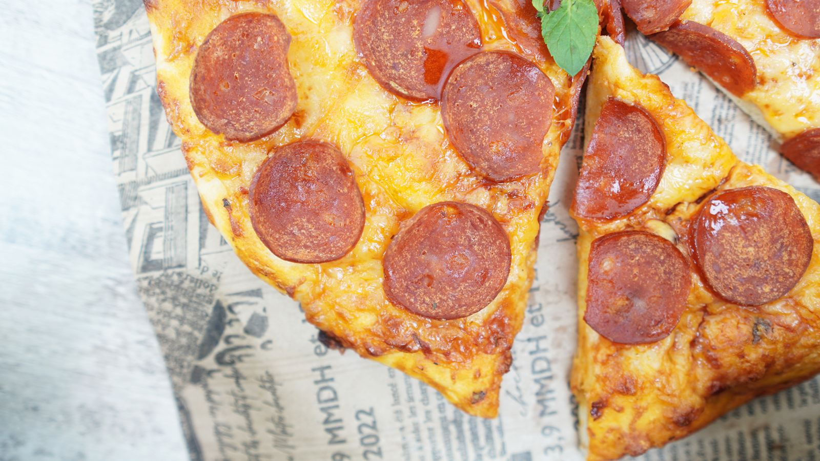 Close-up of pepperoni pizza slices with melted mozzarella and glossy pepperoni
