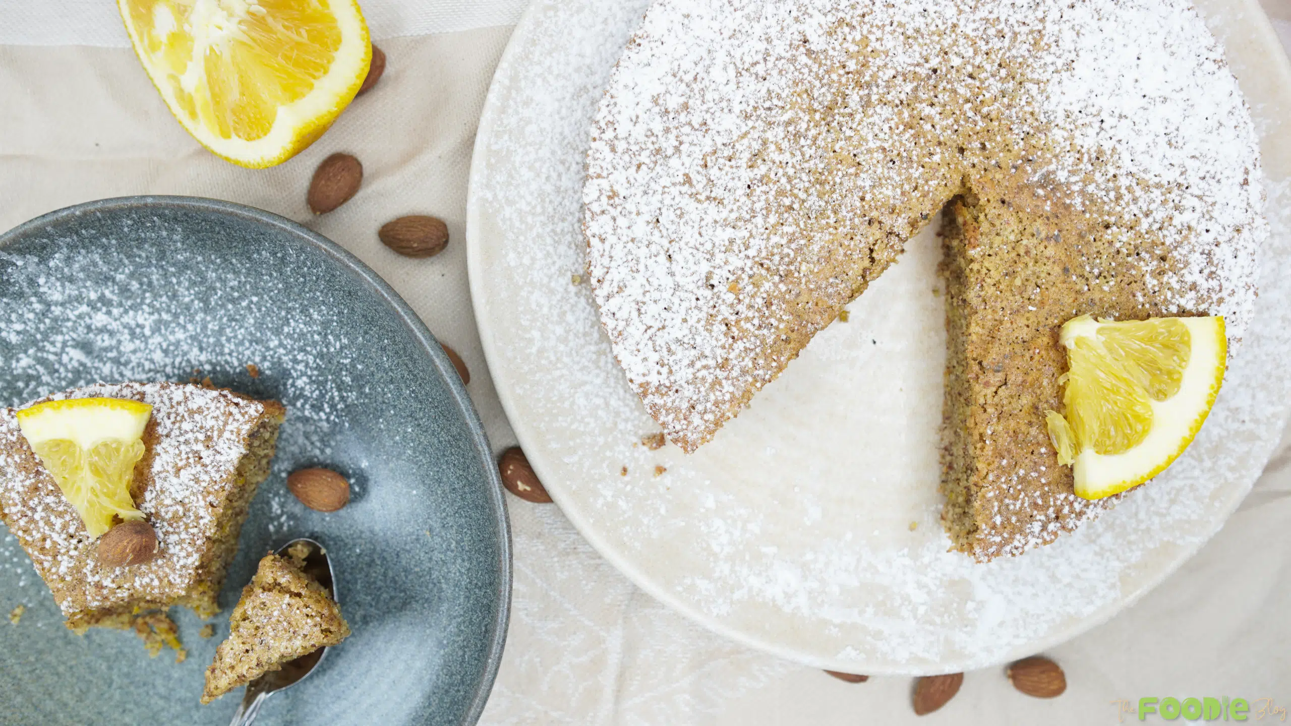 Overhead view of Italian Almond Cake dusted with powdered sugar with a slice removed