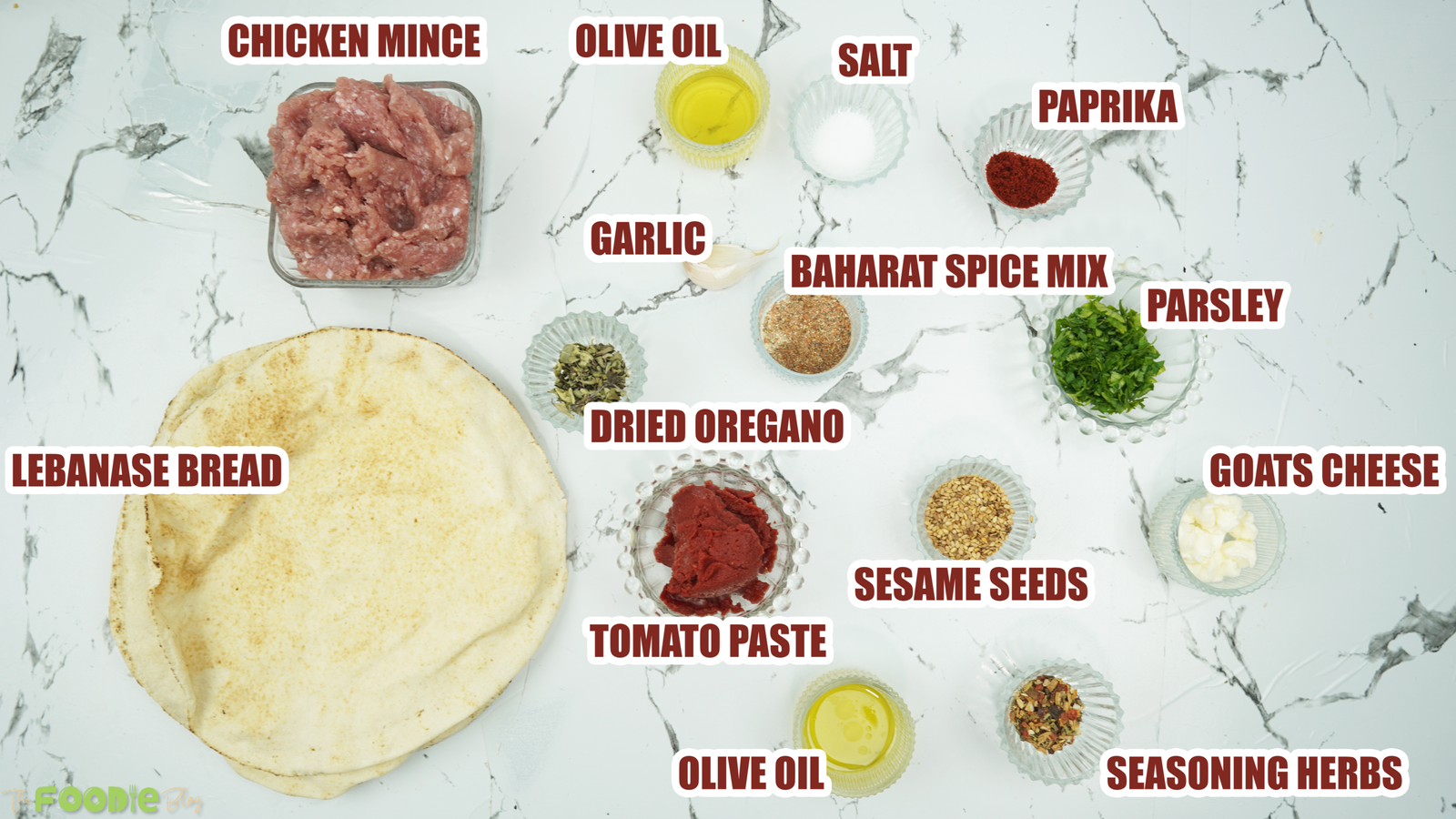 Ingredients laid out for Lebanese flatbread pizza including chicken mince, spices, tomato paste, olive oil, herbs, and Lebanese bread