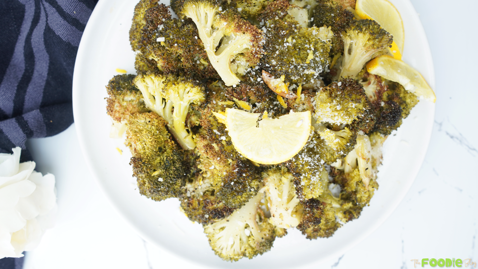 Close-up of crispy roasted broccoli with lemon slices and Parmesan