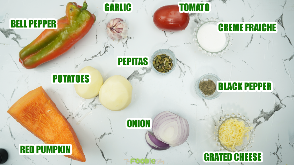 Ingredients for oven roasted veggie soup on a white marble surface