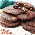 Chocolate peanut butter cookies stacked with a broken cookie showing the peanut butter layer inside