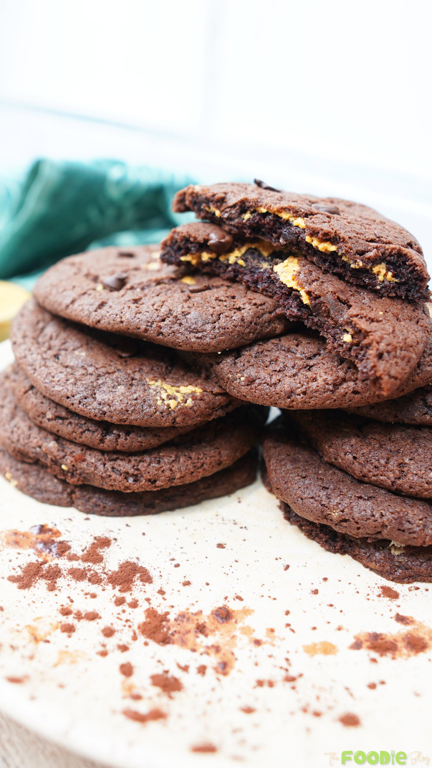Chocolate peanut butter cookies stacked with a broken cookie showing the peanut butter layer inside