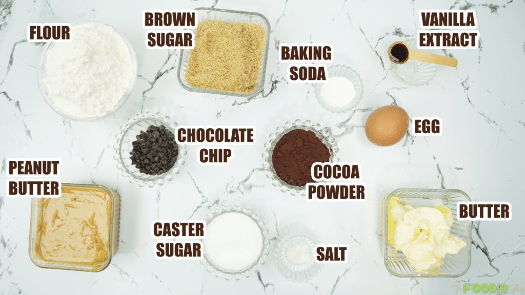 Ingredients for peanut butter cookies including flour, sugars, cocoa powder, peanut butter, butter, egg, vanilla, and chocolate chips.