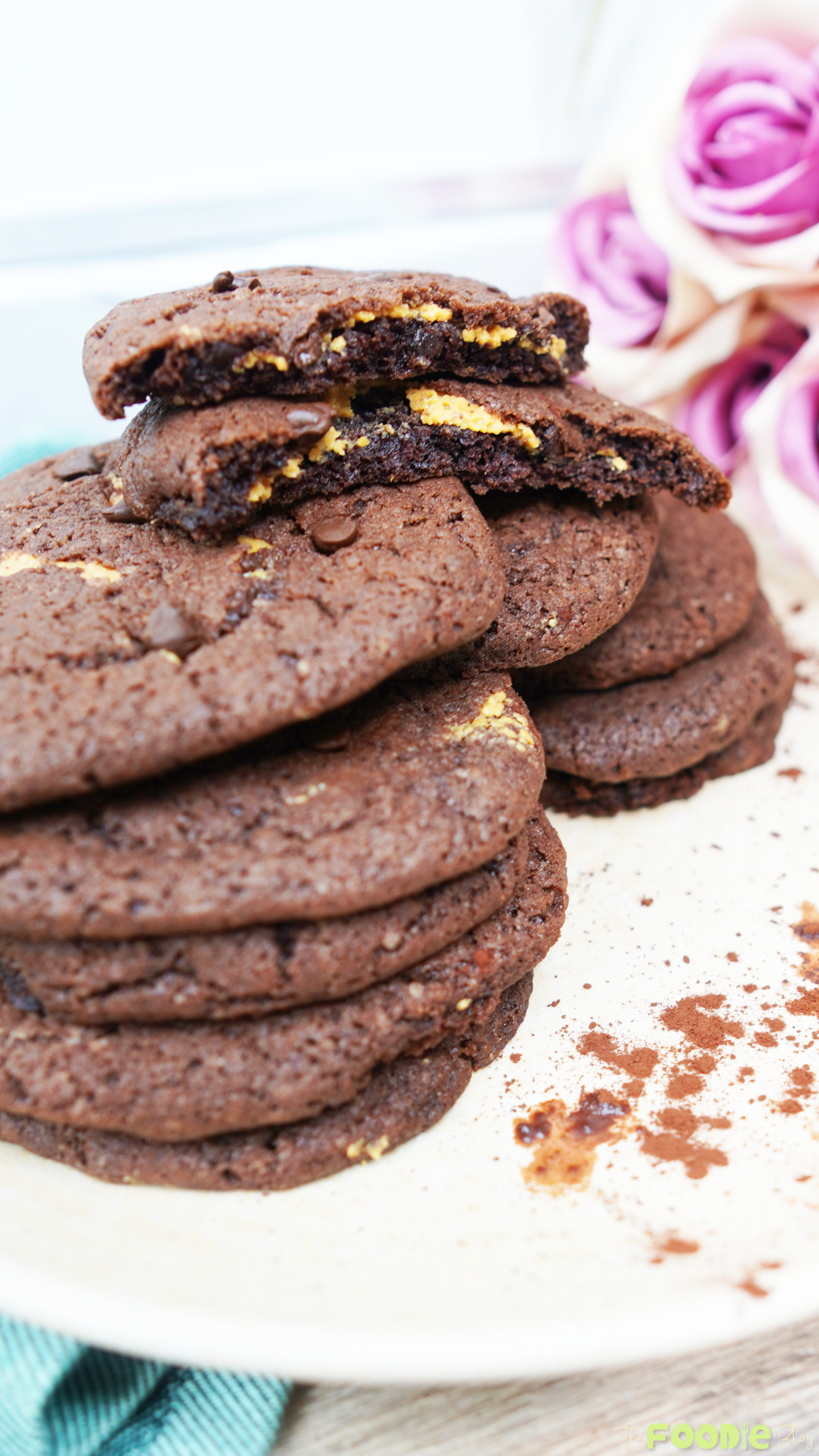 Close-up of a stack of chocolate peanut butter cookies with a broken cookie on top showing the peanut butter center