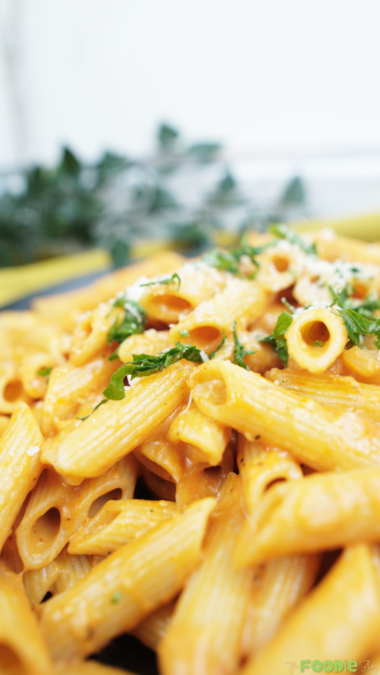 Close-up of penne coated in creamy tomato vodka sauce with Parmesan and parsley