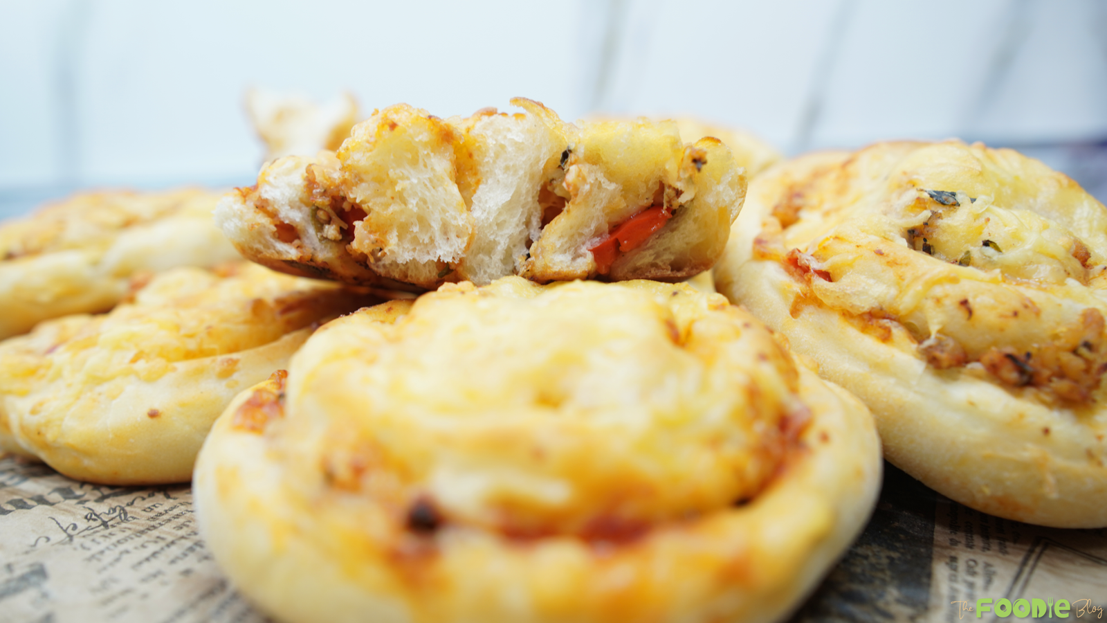 A torn piece of Pizza Roll resting on top, showing the soft bread and savory filling