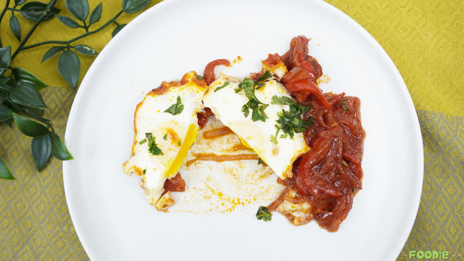Top-down view of plated shakshuka with eggs, tomato sauce, and parsley
