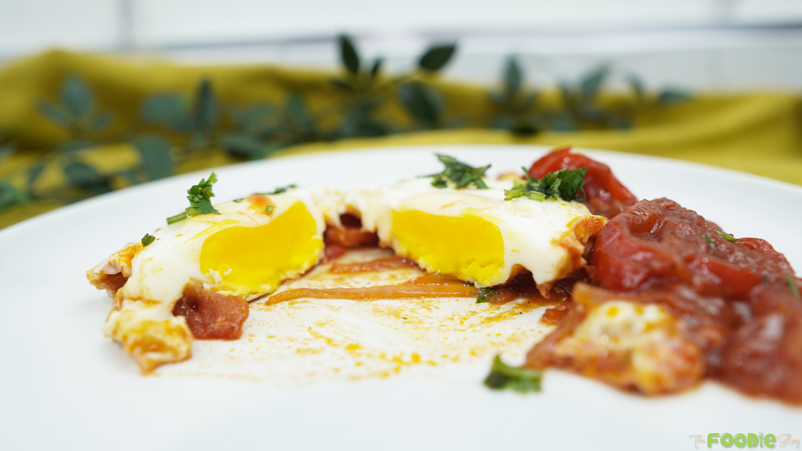 Close-up of shakshuka with soft eggs in a rich tomato and onion sauce
