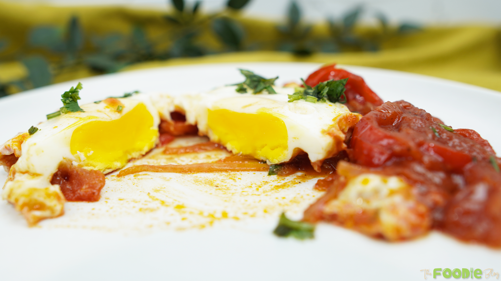 Close-up of shakshuka with soft eggs in a rich tomato and onion sauce
