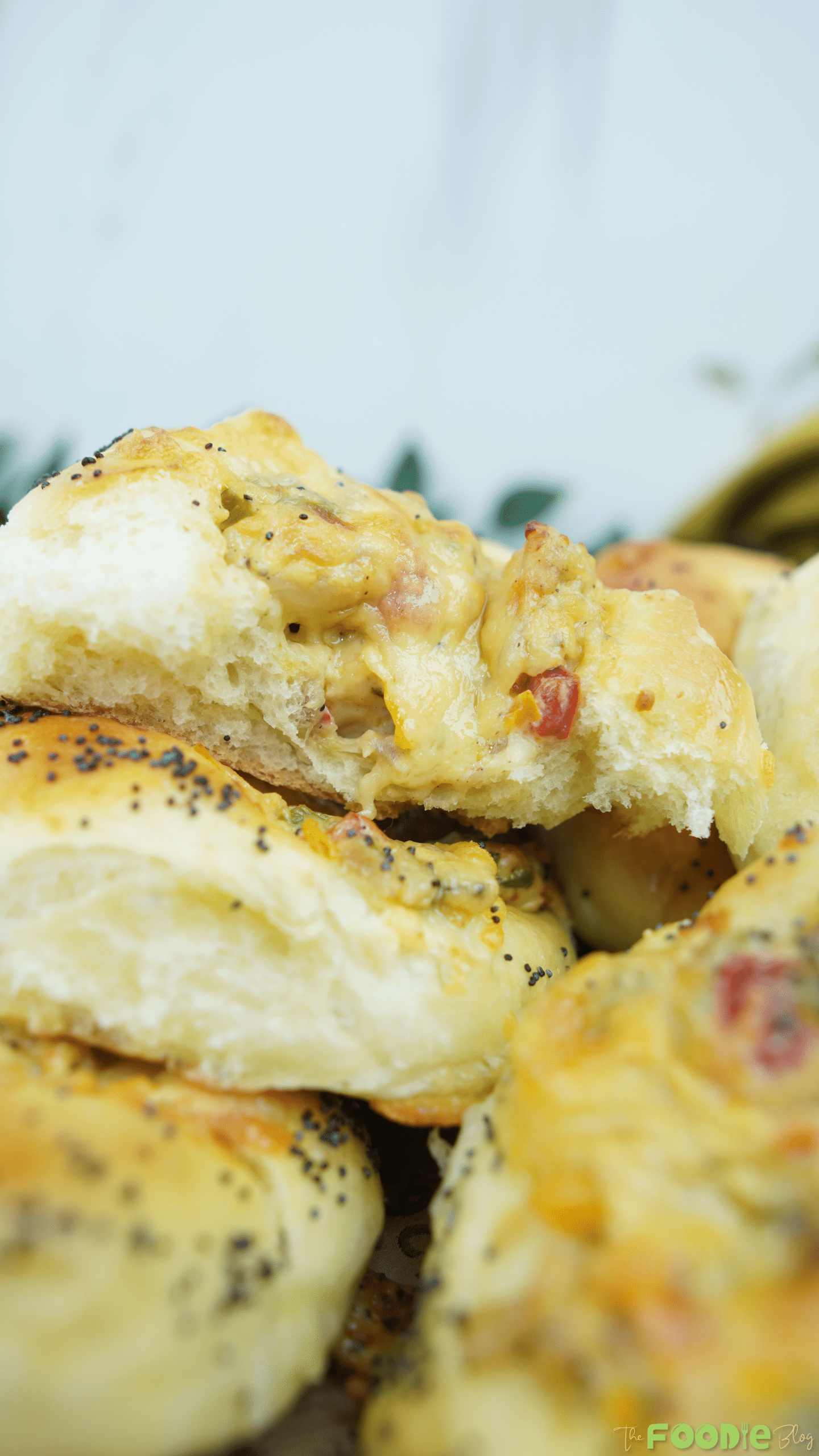 A soft cheese pizza bun pulled apart to show the fluffy interior and creamy, cheesy filling