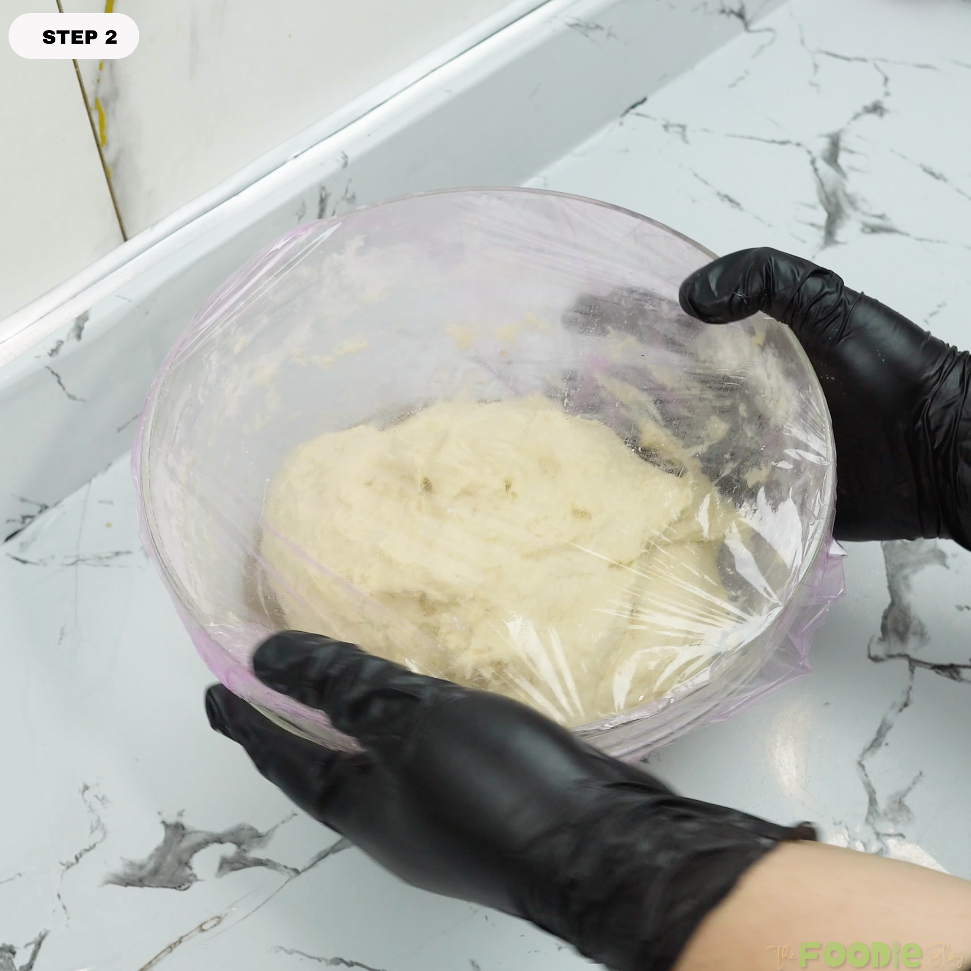 Dough in a bowl covered with plastic wrap for the first rise