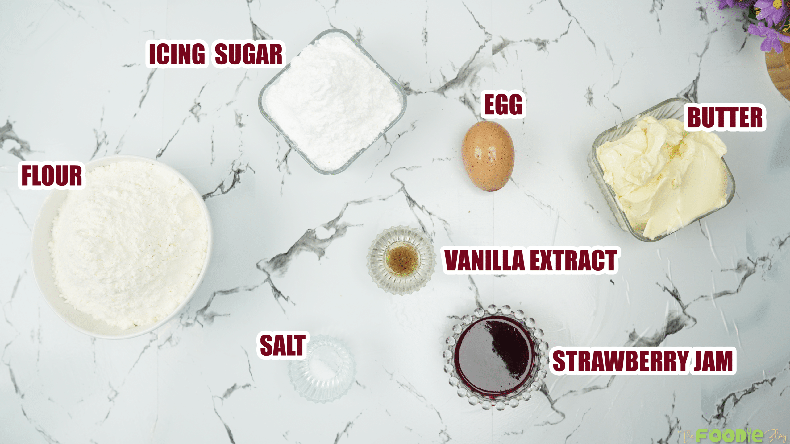 Ingredients laid out for thumbprint cookies including butter, powdered sugar, egg, vanilla, flour, salt, and strawberry jam