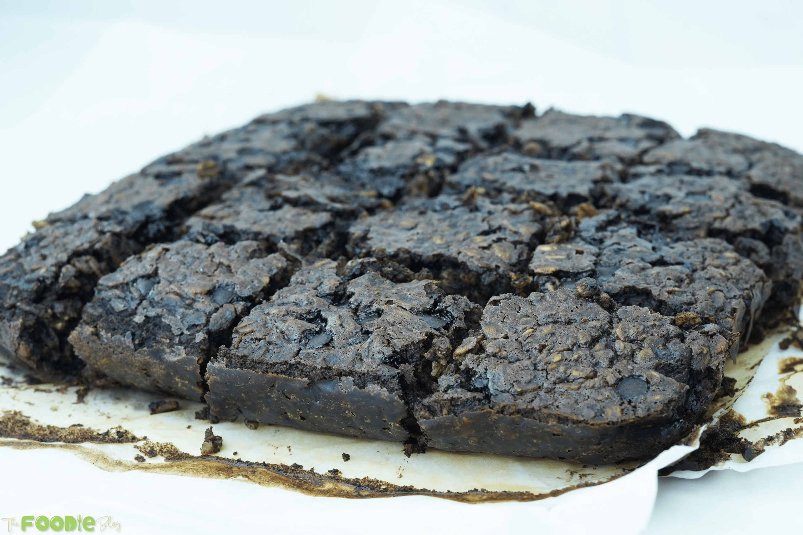 Fudgy oatmeal brownie cut into squares in a lined pan