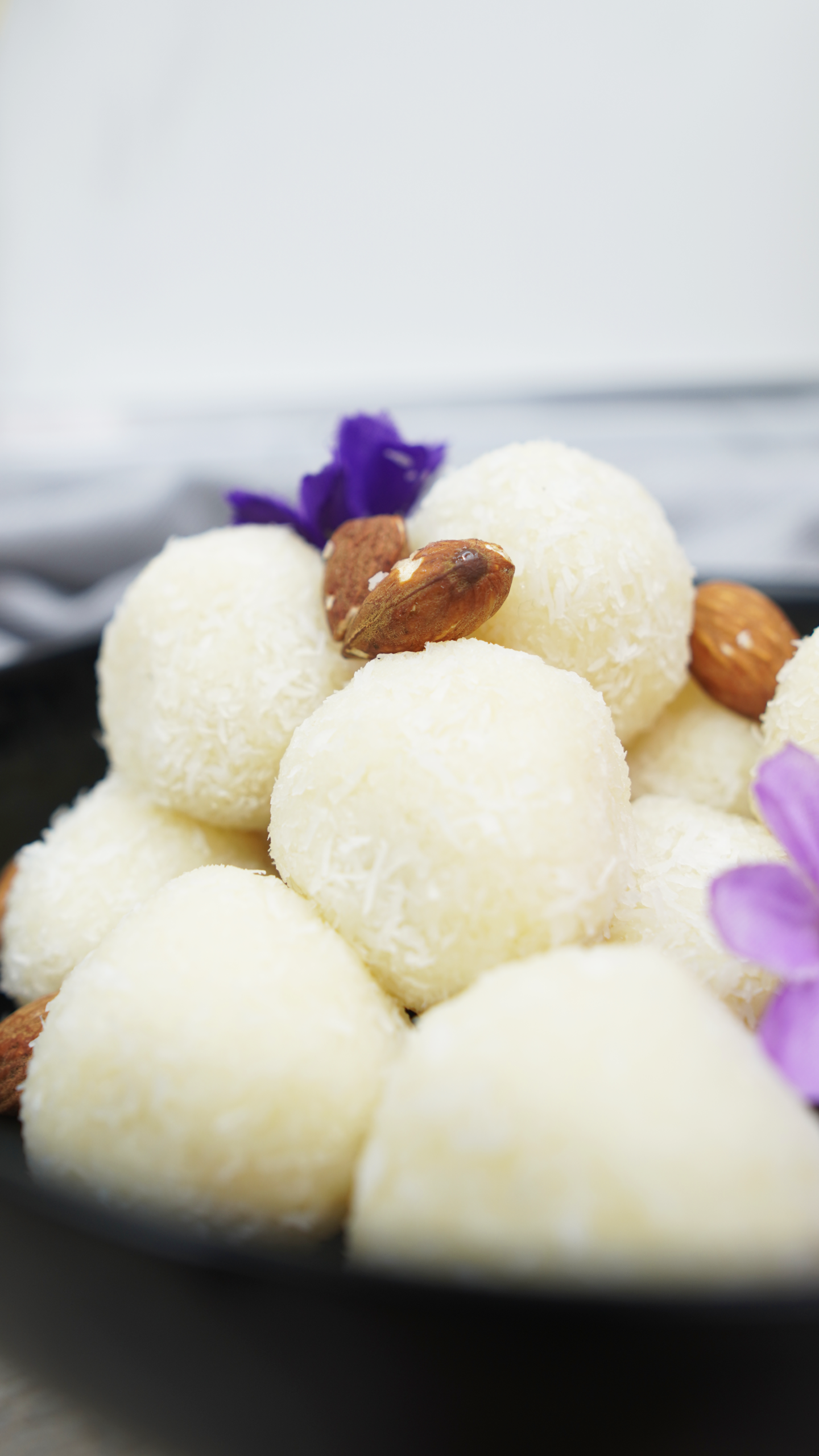 Close-up of coconut-coated balls with almonds in the bowl