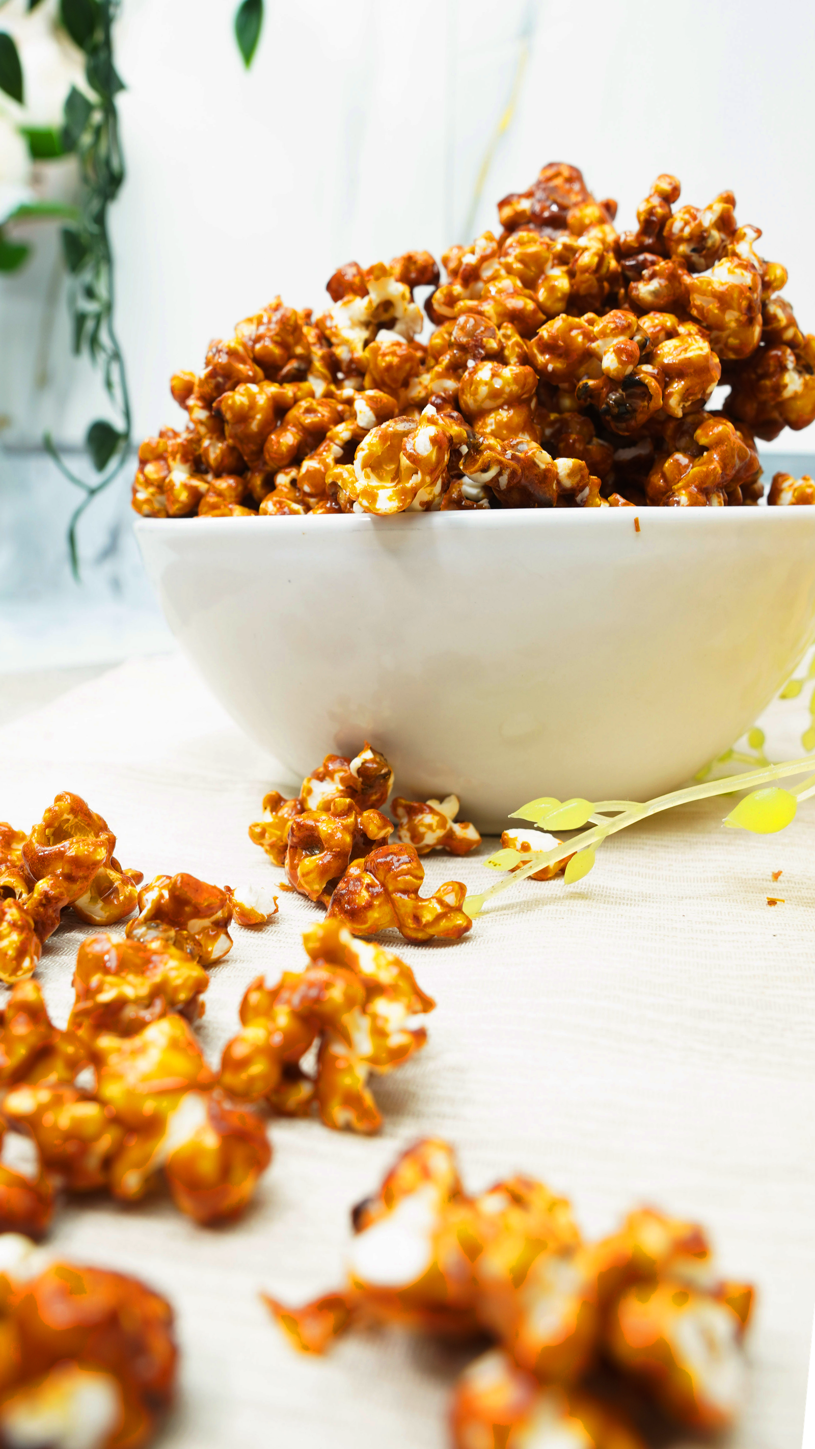 Bowl of caramel popcorn on a bright table with a soft, airy background

