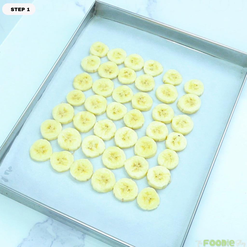 Banana slices arranged on a parchment-lined tray