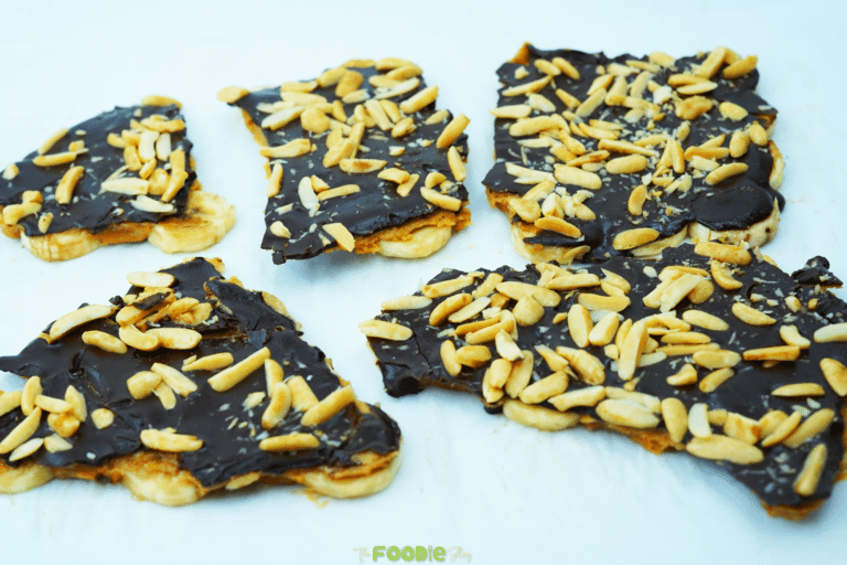Several pieces of chocolate banana bark laid out with crushed peanuts on top