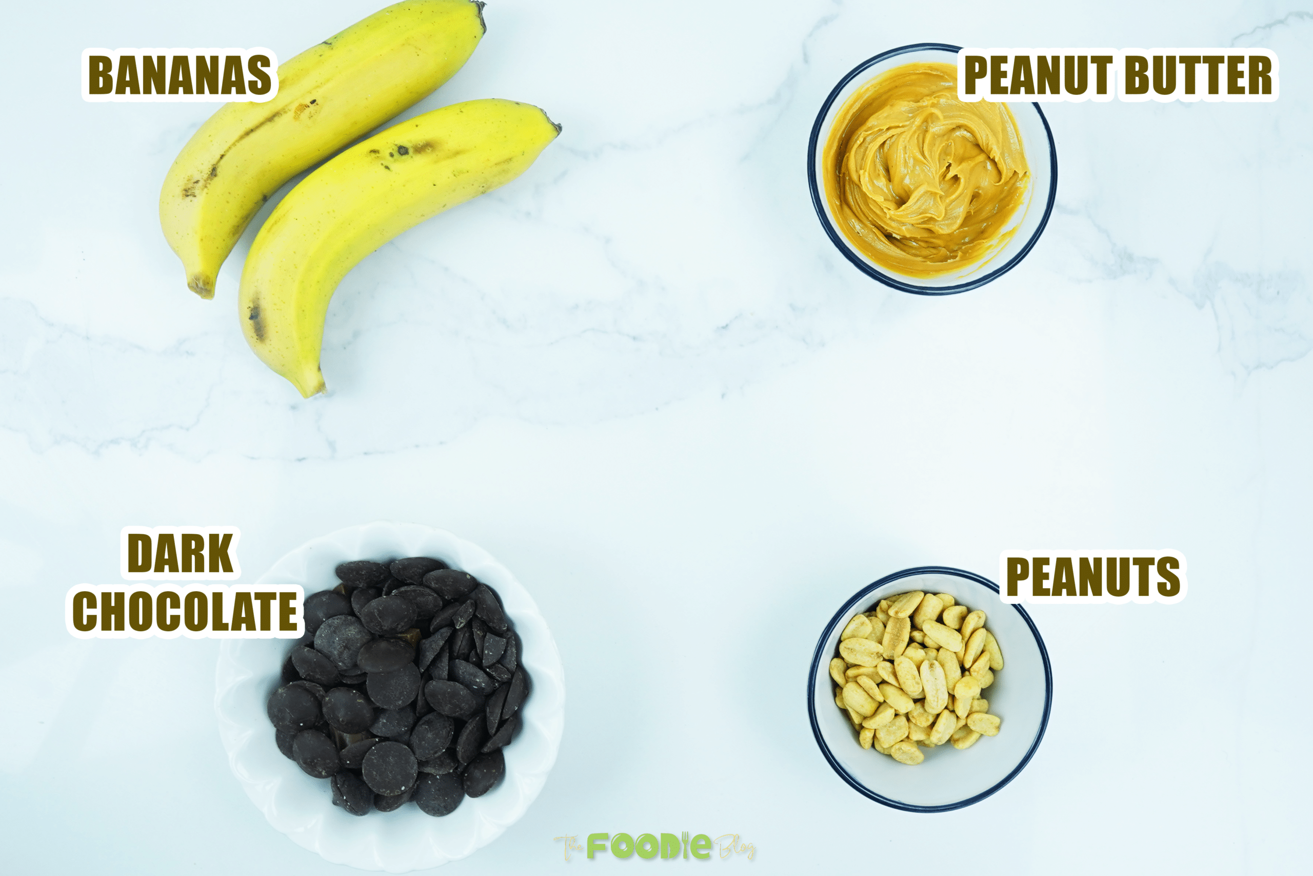Bananas, peanut butter, dark chocolate, and peanuts on a white background