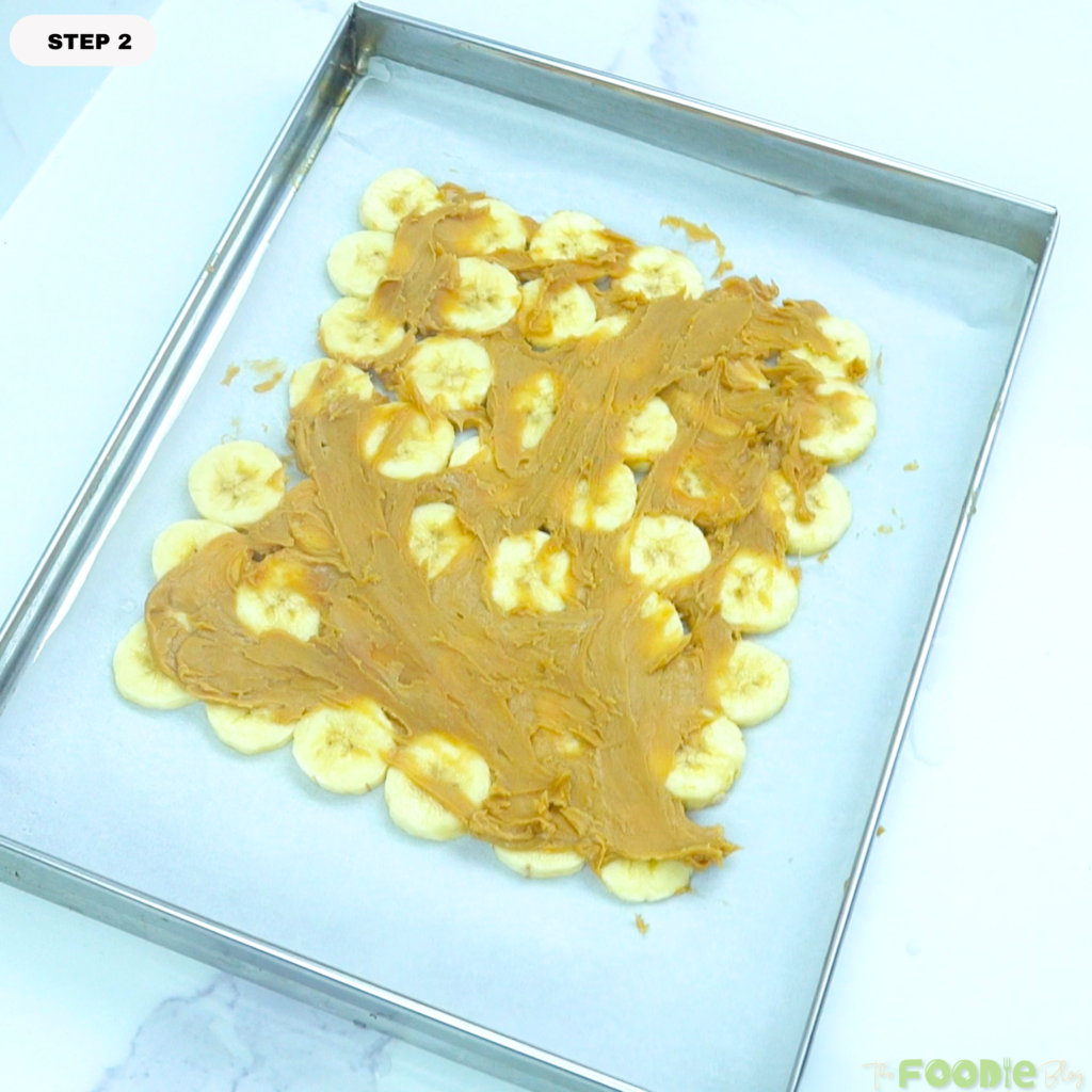 Peanut butter spread over banana slices on a tray