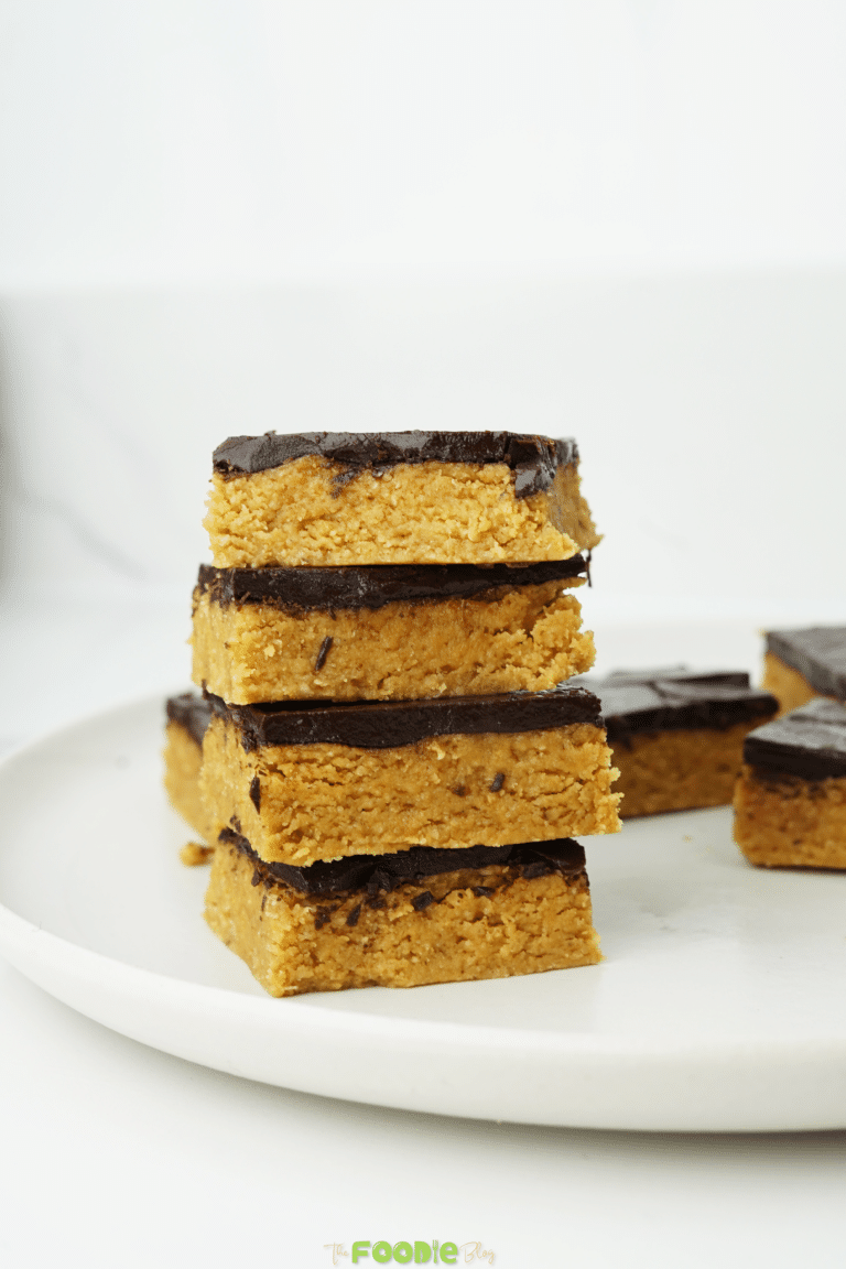 Chocolate peanut butter bars with a dark chocolate topping on a white plate