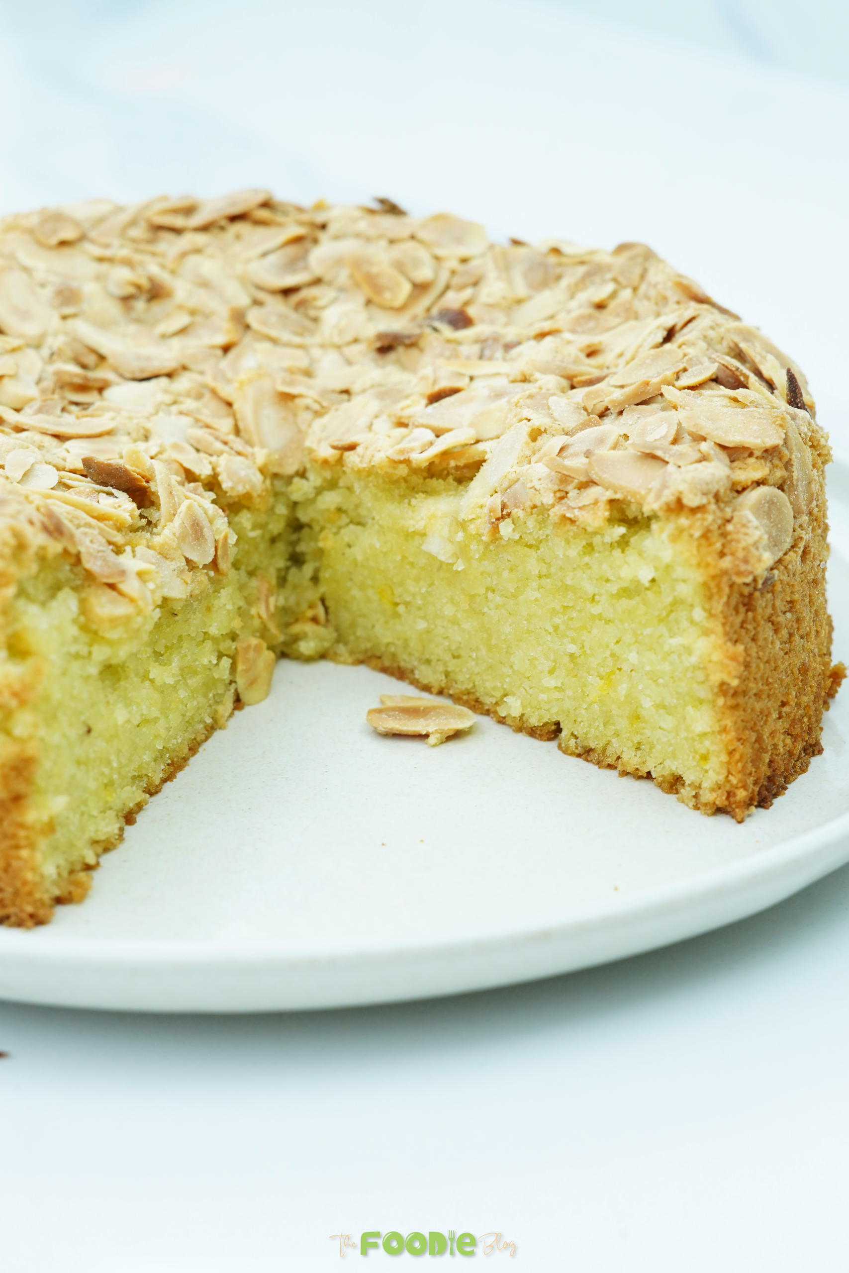 Flourless almond cake with a wedge cut out showing the soft yellow interior