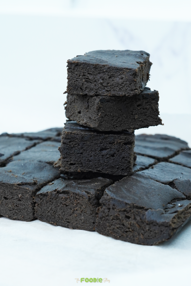 Close-up of three stacked brownie squares showing a dense, fudgy crumb