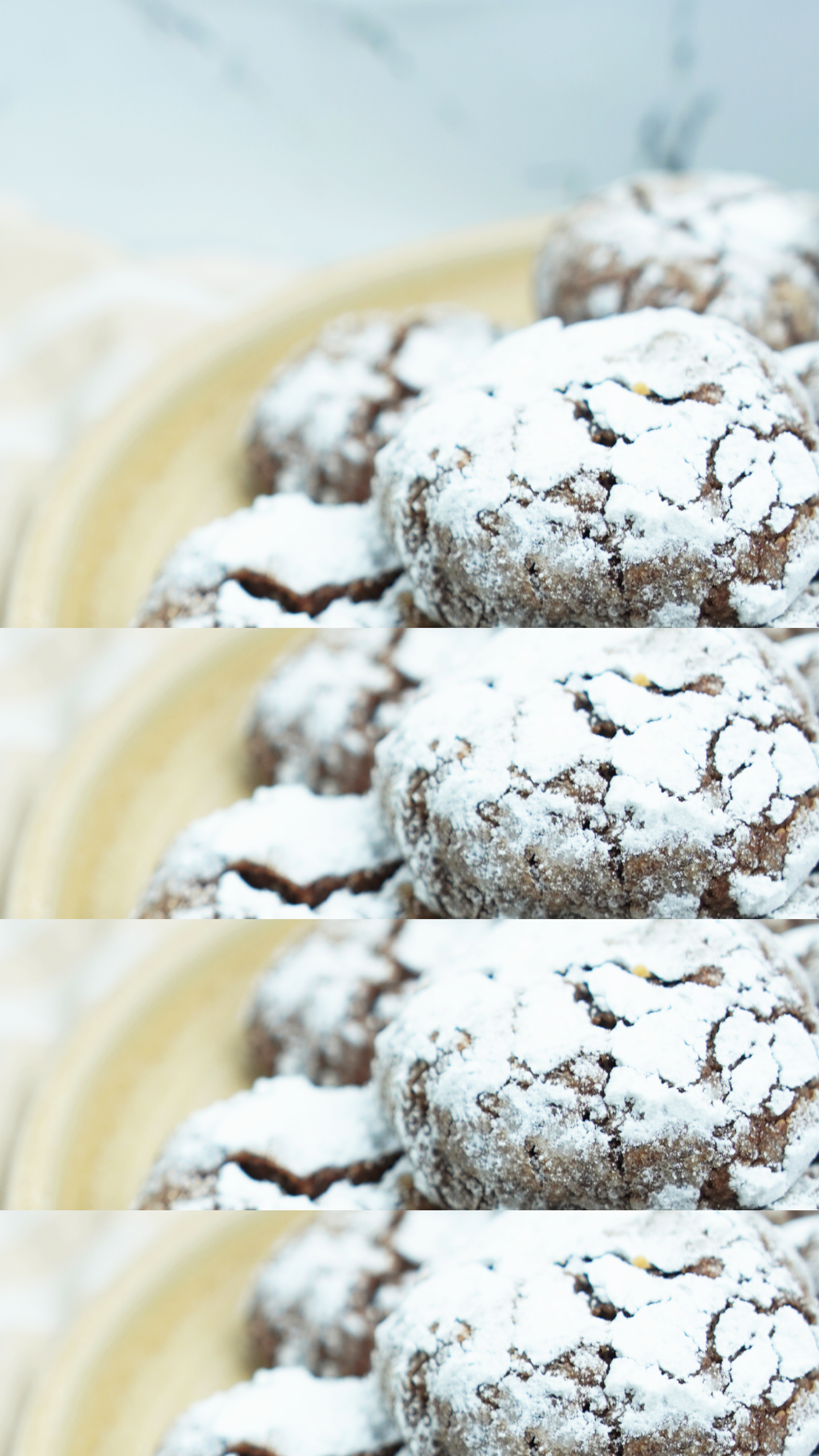 Close-up of powdered sugar–coated cocoa crinkle cookies on a ceramic plate