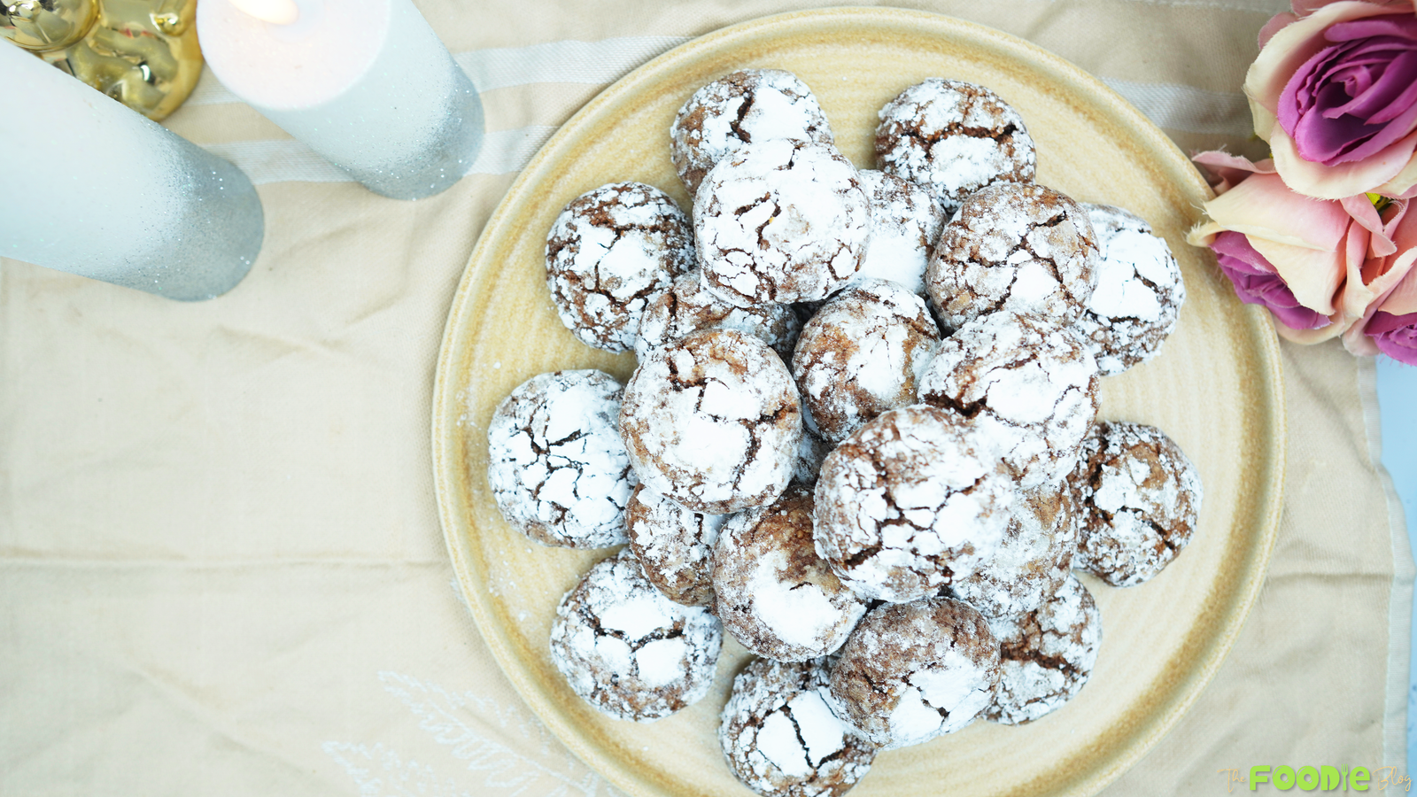 Overhead view of Nutty Cocoa Fudge Cookies coated in powdered sugar and arranged on a serving plate.