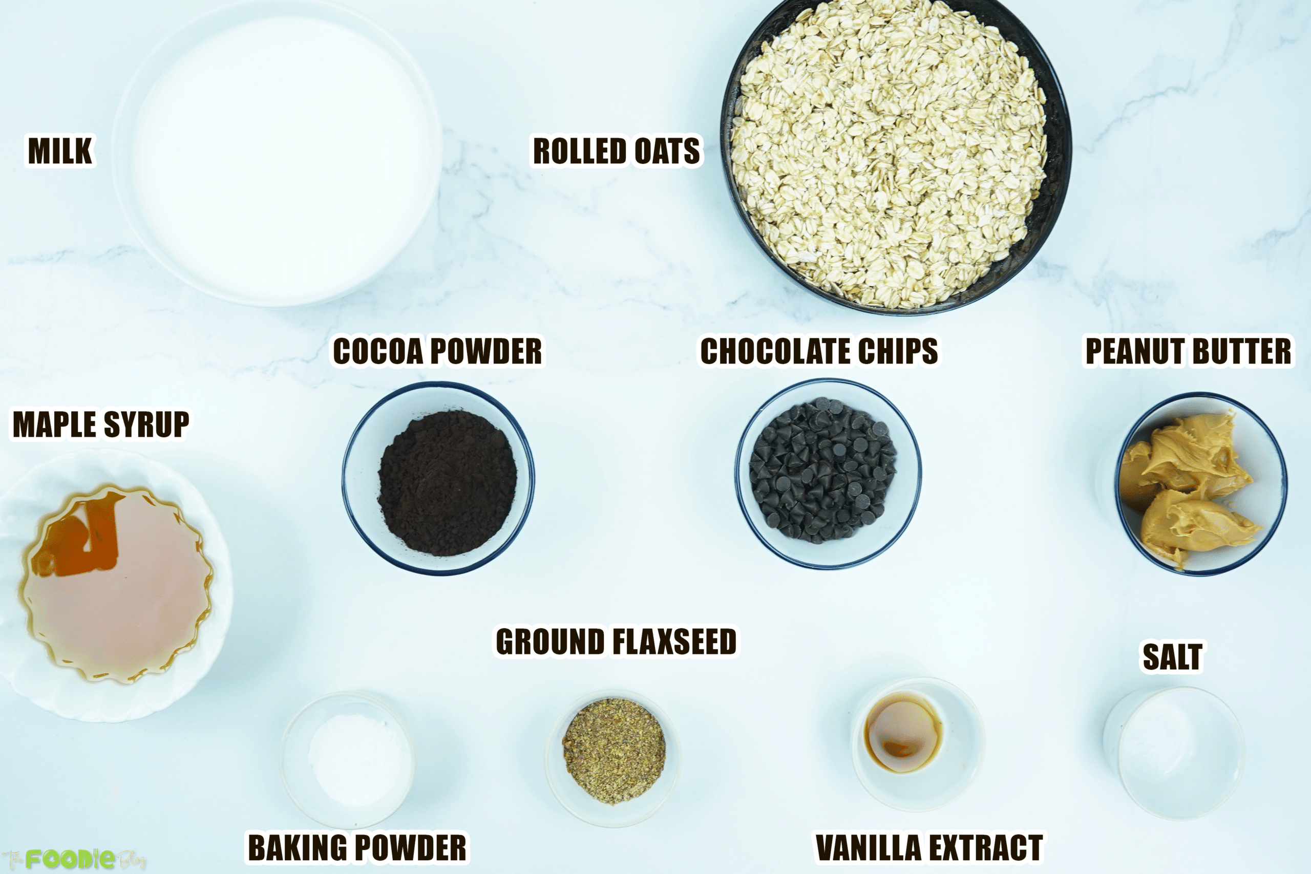 Overhead view of oats, milk, cocoa powder, peanut butter, maple syrup, and other ingredients