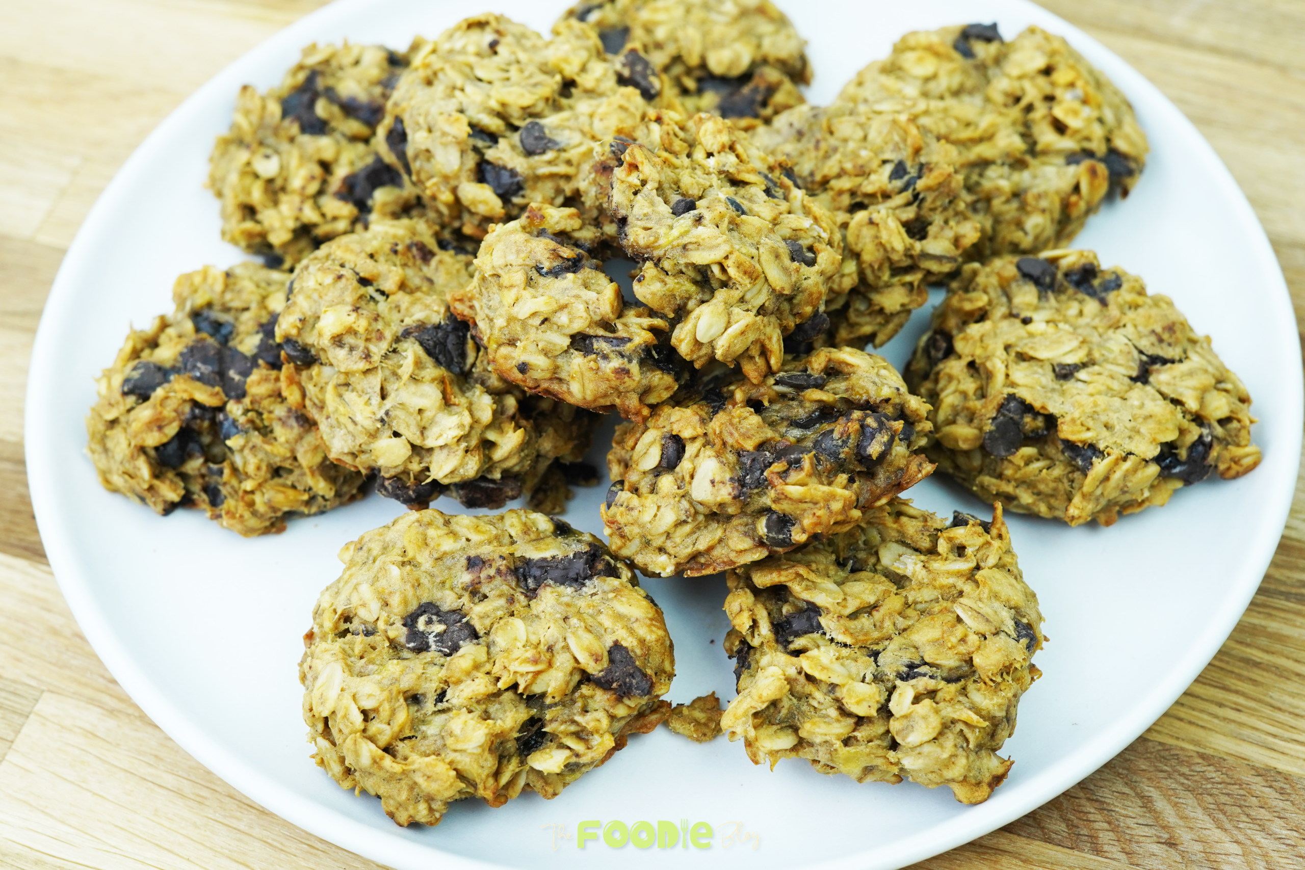 Oatmeal chocolate chip cookies piled on a white plate