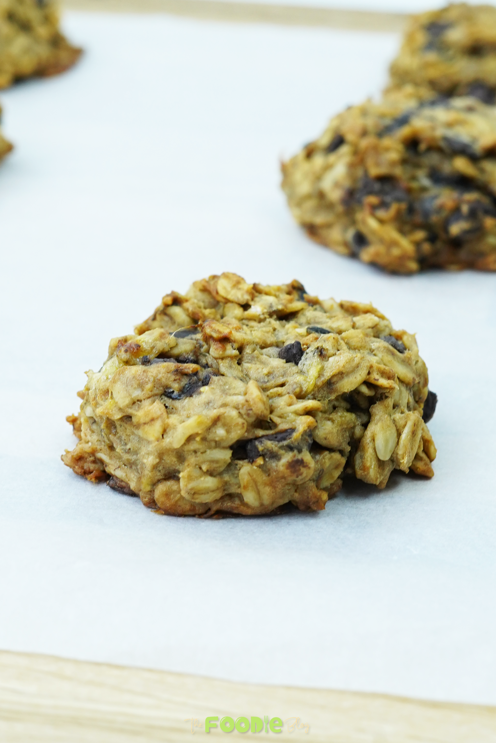 Close-up of an oatmeal chocolate chip cookie on parchment paper