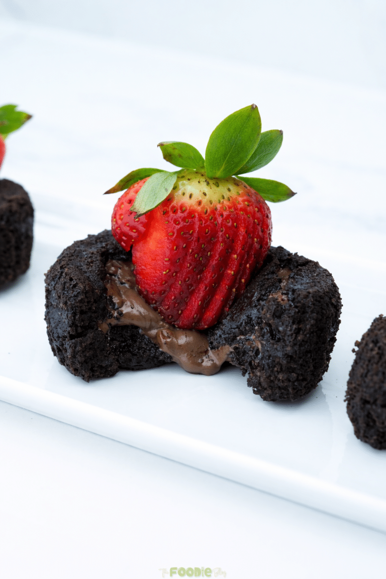 Close-up of a chocolate lava cake with melted chocolate inside and a strawberry on top