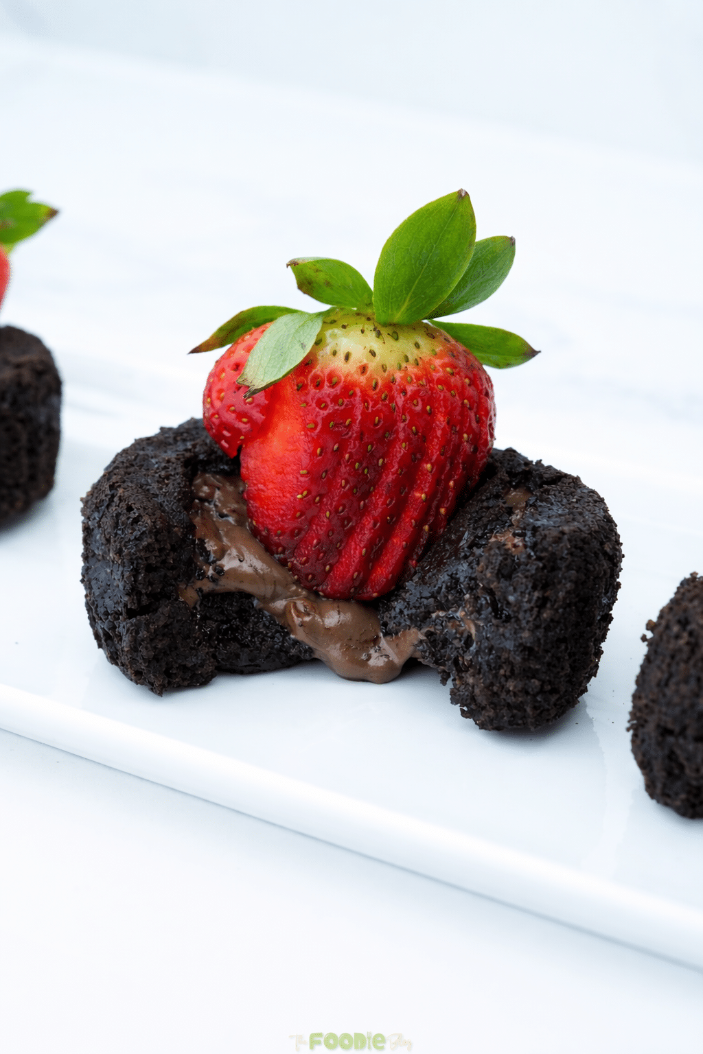 Close-up of a chocolate lava cake with melted chocolate inside and a strawberry on top