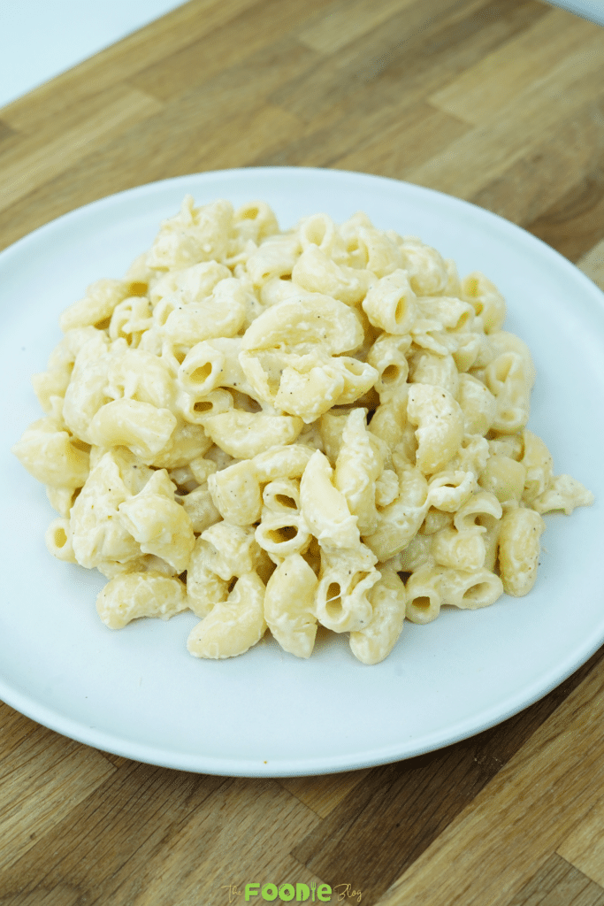 Creamy macaroni and cheese made with elbow pasta and a smooth cheddar cheese sauce served on a white