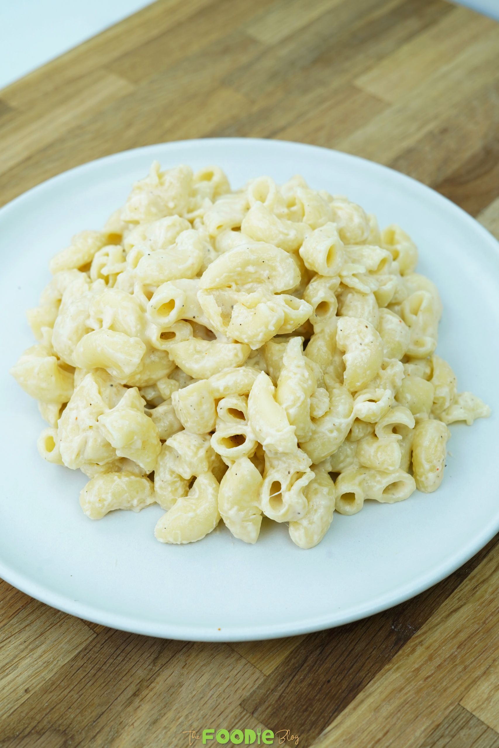 Creamy one pot mac and cheese served in a white bowl on a wooden surface