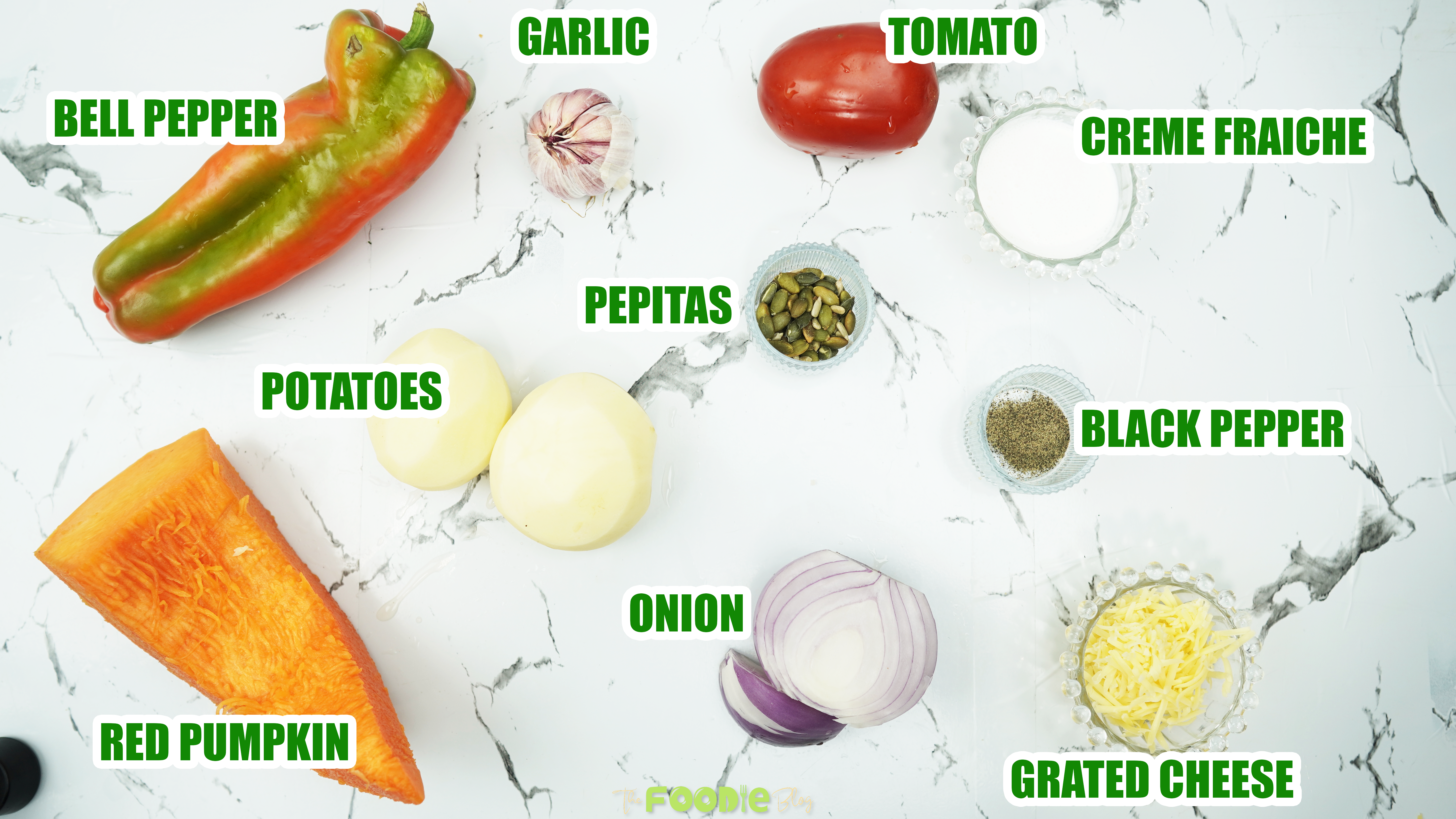 Ingredients for oven roasted veggie soup on a white marble surface
