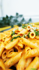 Close-up of penne coated in creamy tomato vodka sauce with Parmesan and parsley