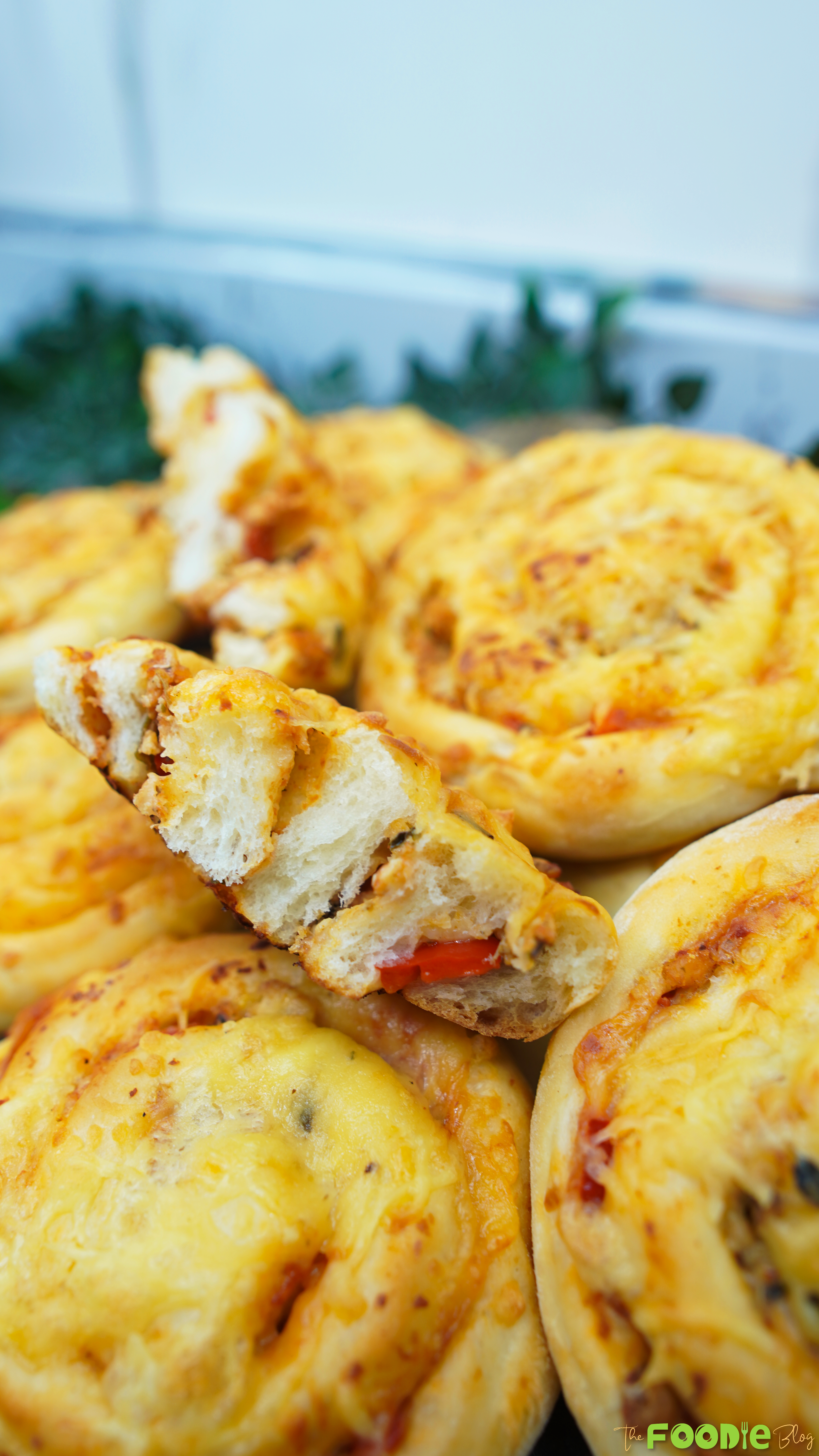 Close-up of cheesy Pizza Rolls with golden tops and a visible spiral shape
