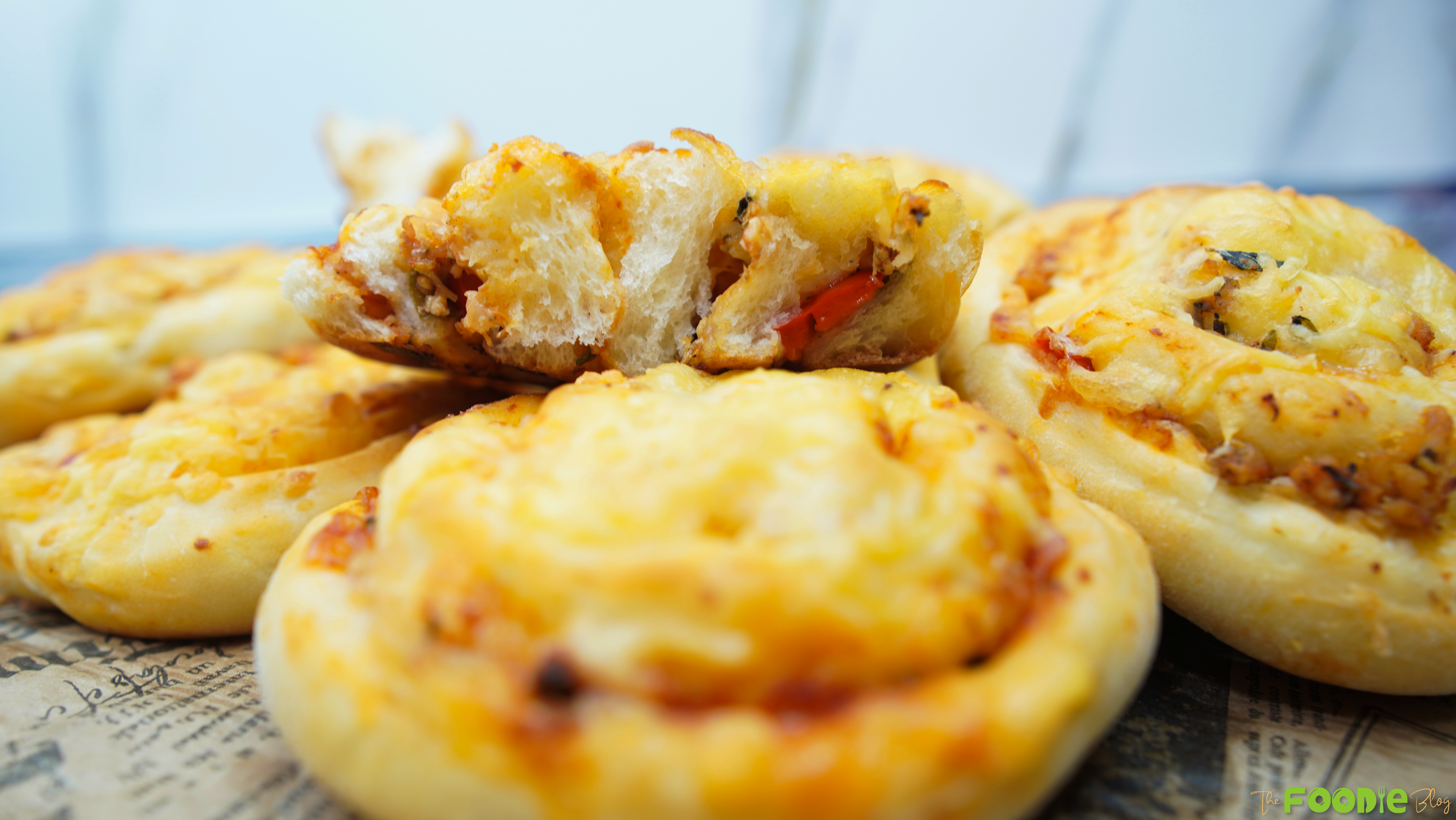 A torn piece of Pizza Roll resting on top, showing the soft bread and savory filling
