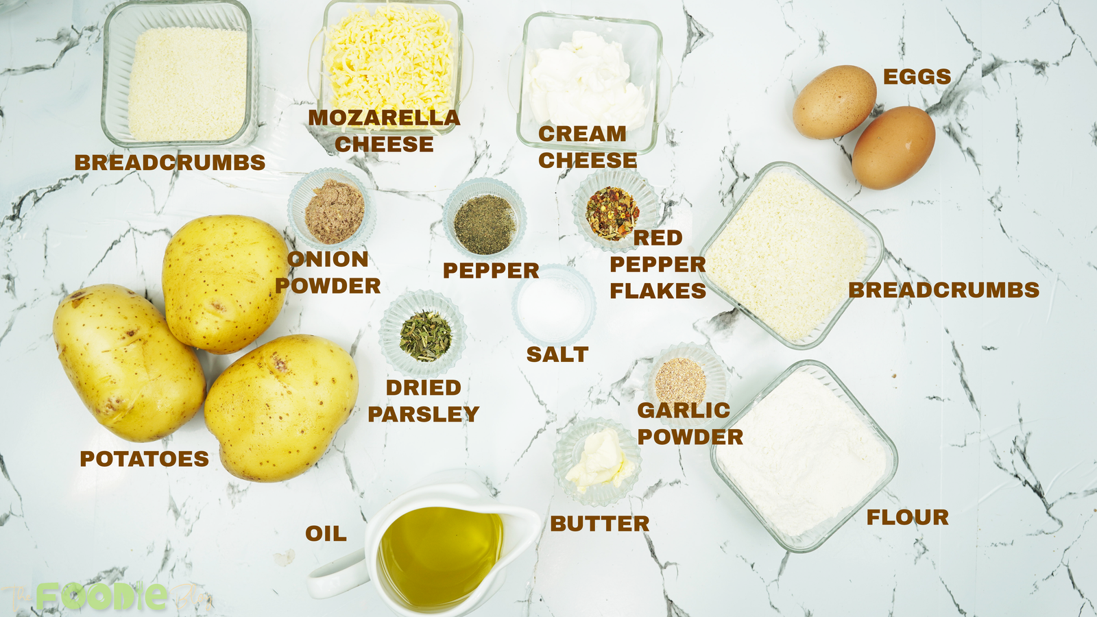 Labeled ingredients for potato cheese balls on a marble counter
