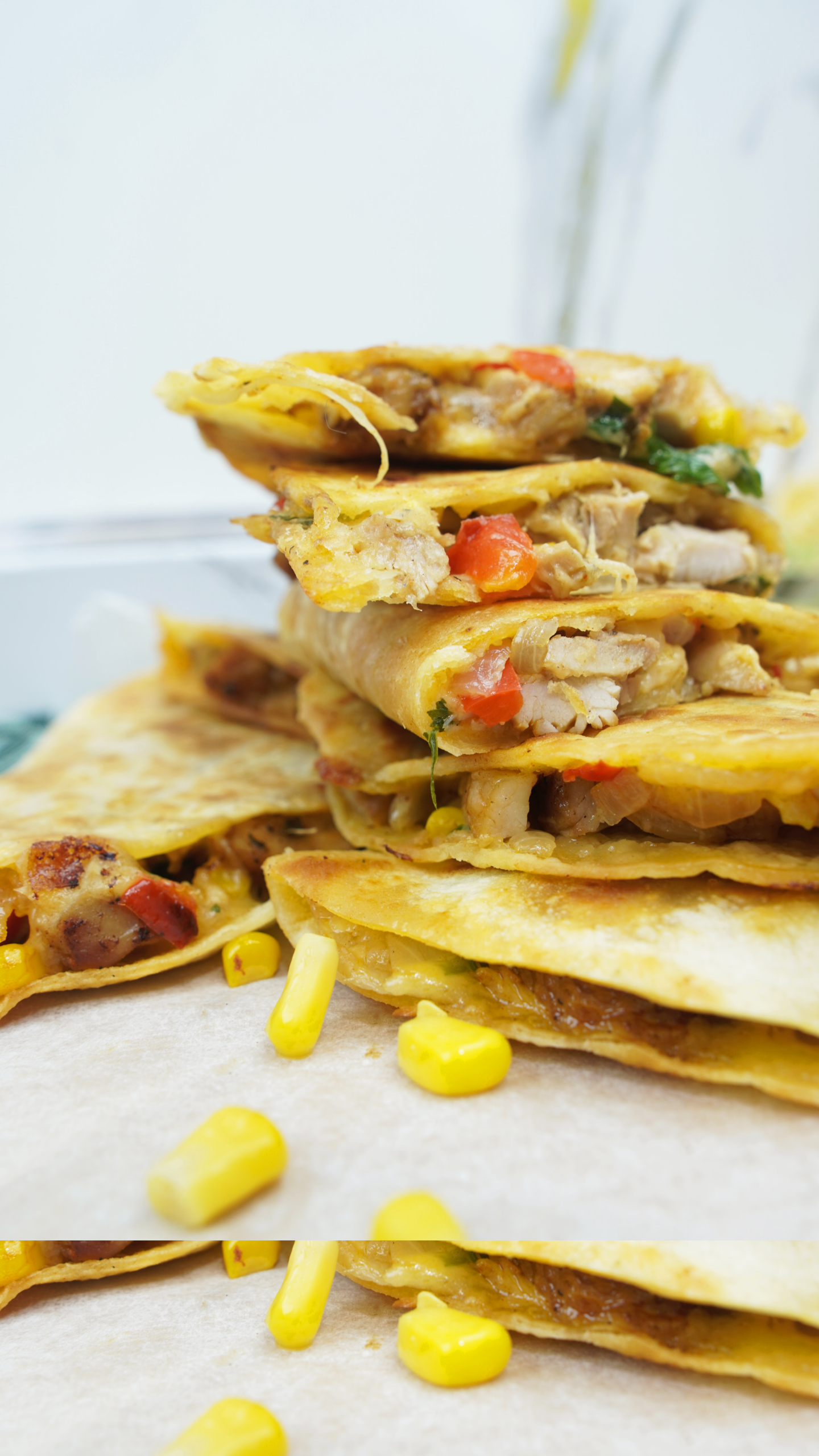 Close-up stack of golden quesadilla wedges with chicken, corn, and melted cheese Caption: Crispy, cheesy chicken quesadilla wedges.