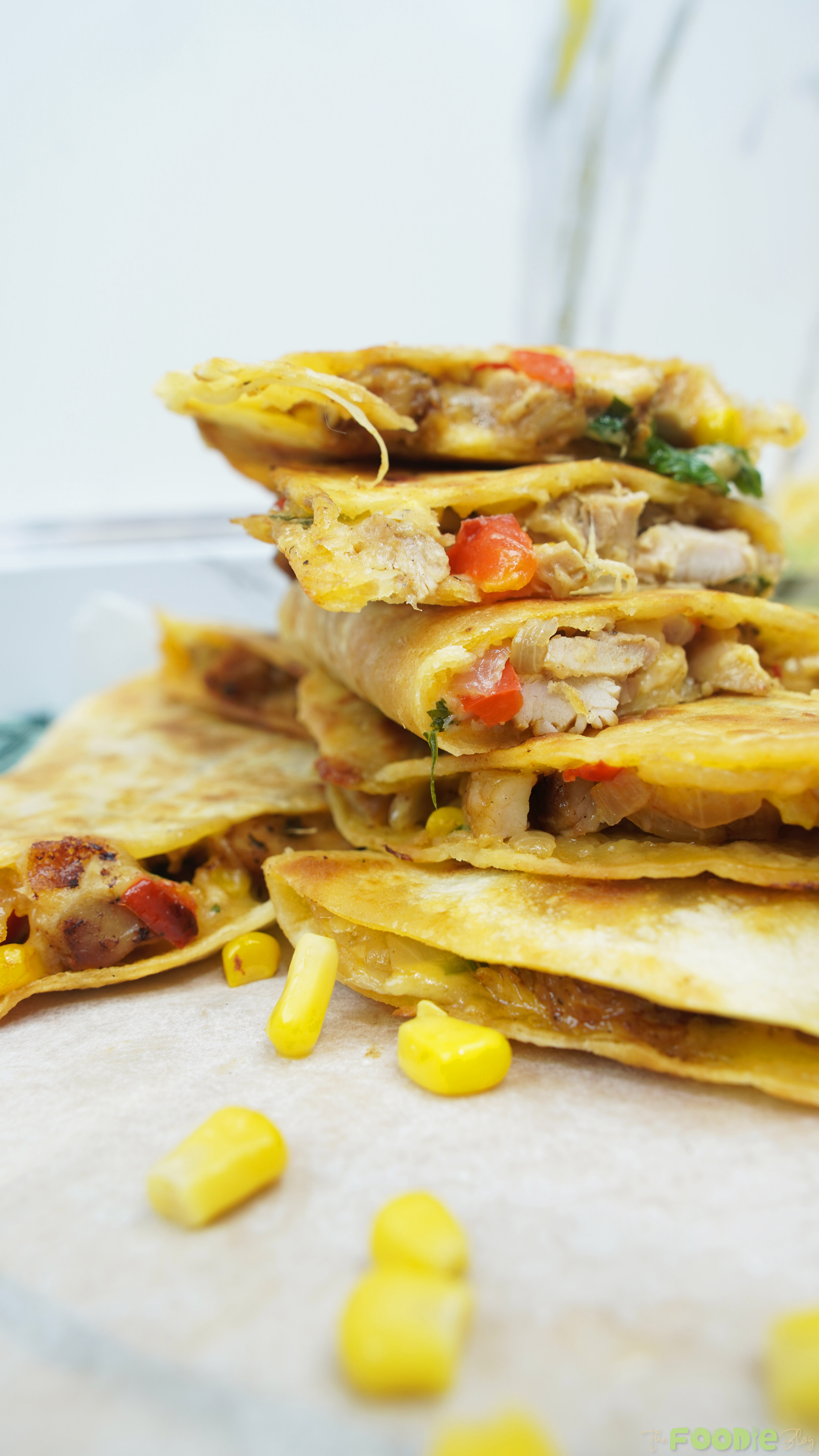 Close-up stack of golden quesadilla wedges with chicken, corn, and melted cheese Caption: Crispy, cheesy chicken quesadilla wedges.
