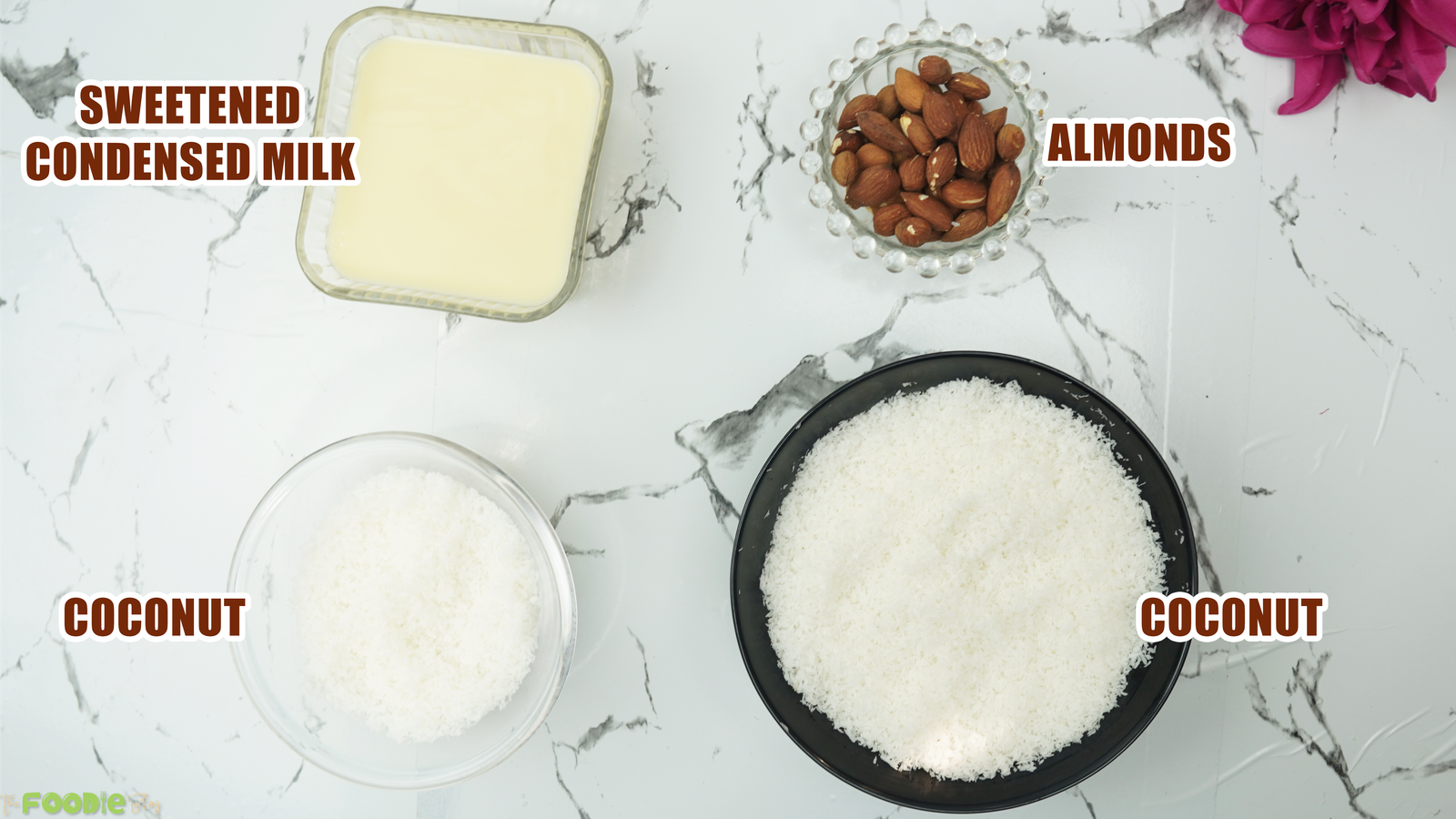 Sweetened condensed milk, shredded coconut, and almonds arranged for the recipe
