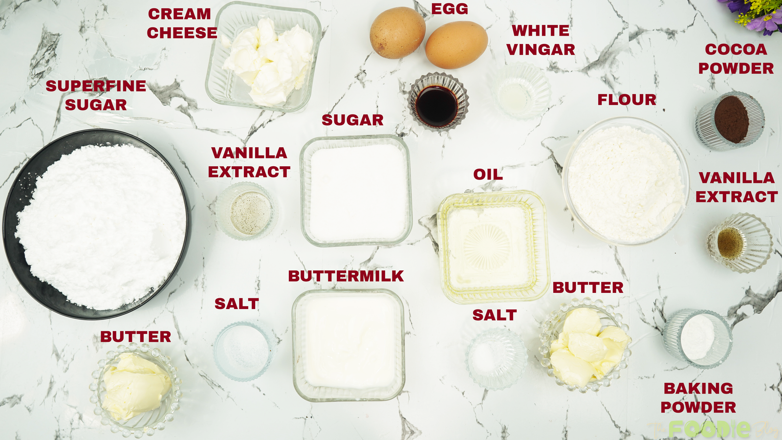 Measured ingredients for red velvet cupcakes and cream cheese frosting on a countertop
