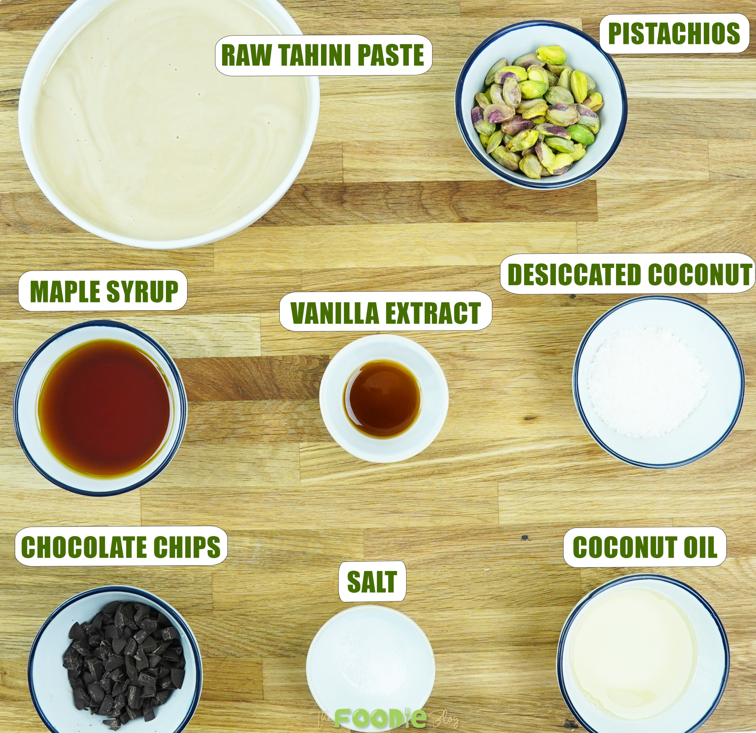 Ingredients for tahini fudge including tahini, maple syrup, pistachios, coconut oil, and mix-ins