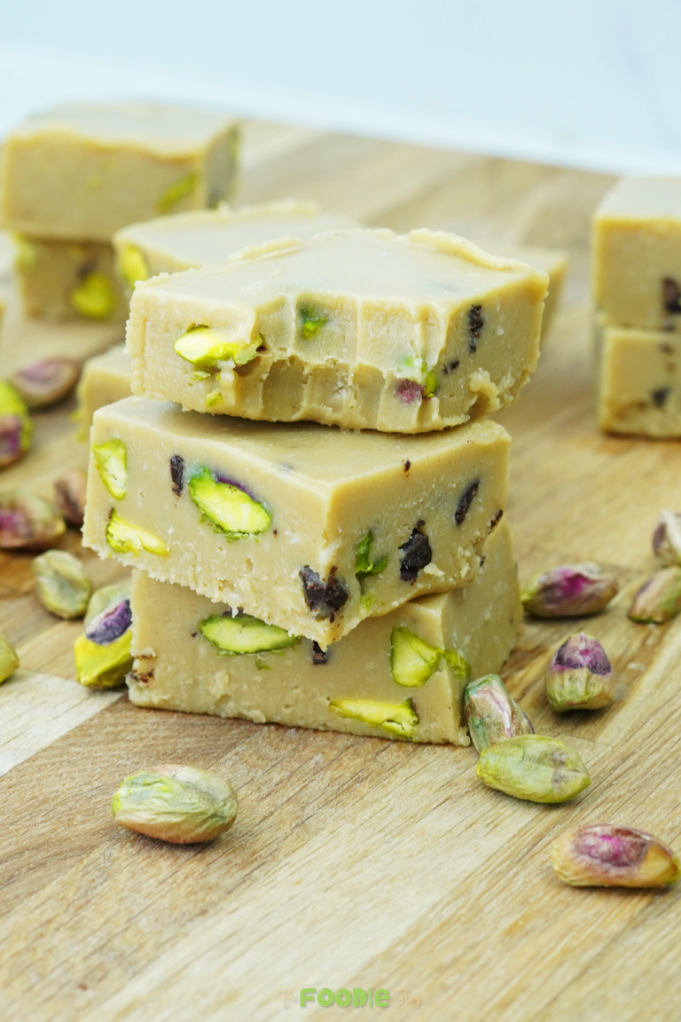 Three tahini fudge bars stacked with pistachios visible in the slices