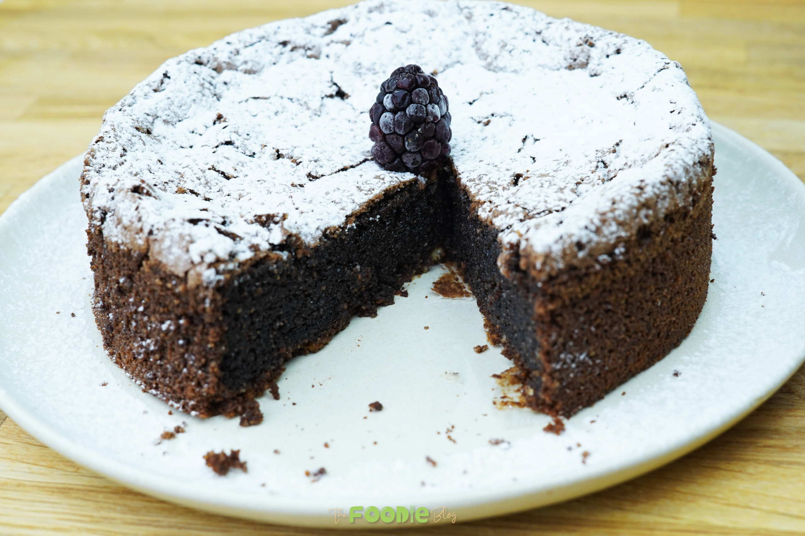 Flourless Italian chocolate cake dusted with powdered sugar on a plate